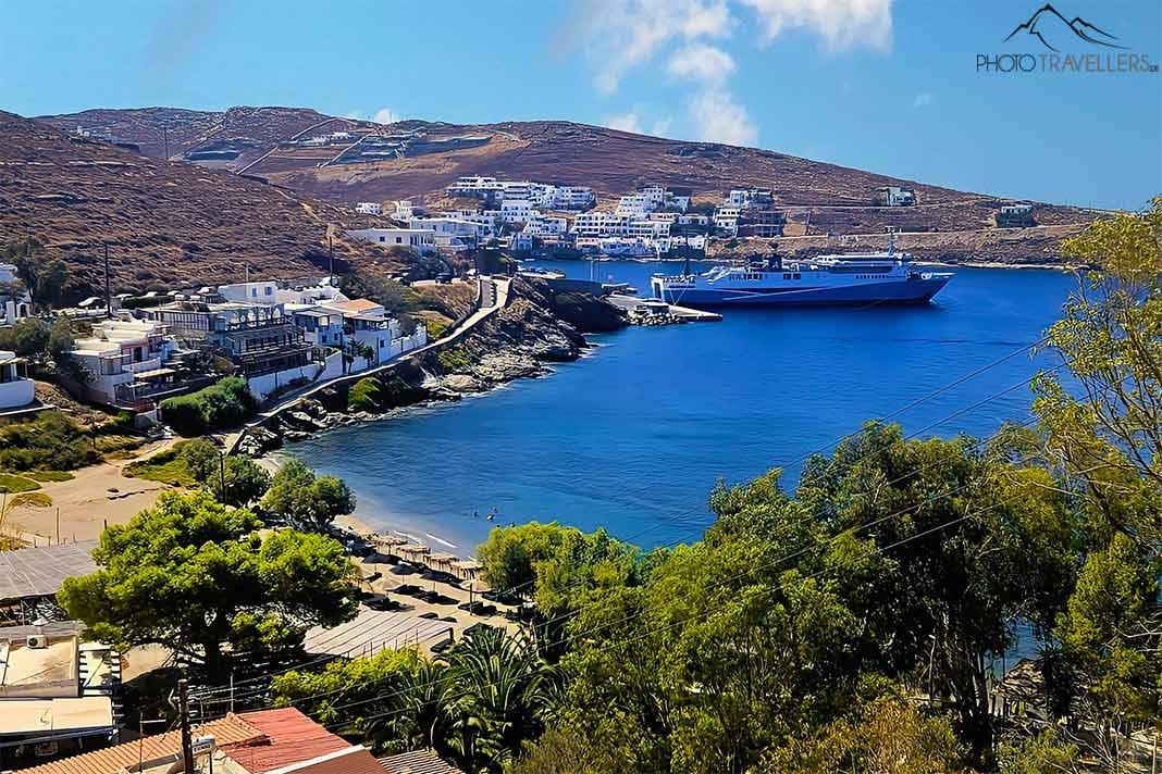Uma grande balsa ancorada no porto de Merichas cercado por colinas arborizadas