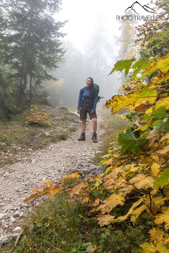 Aventureira Biggi Bauer com equipamento de caminhada em um caminho de longa distância na floresta