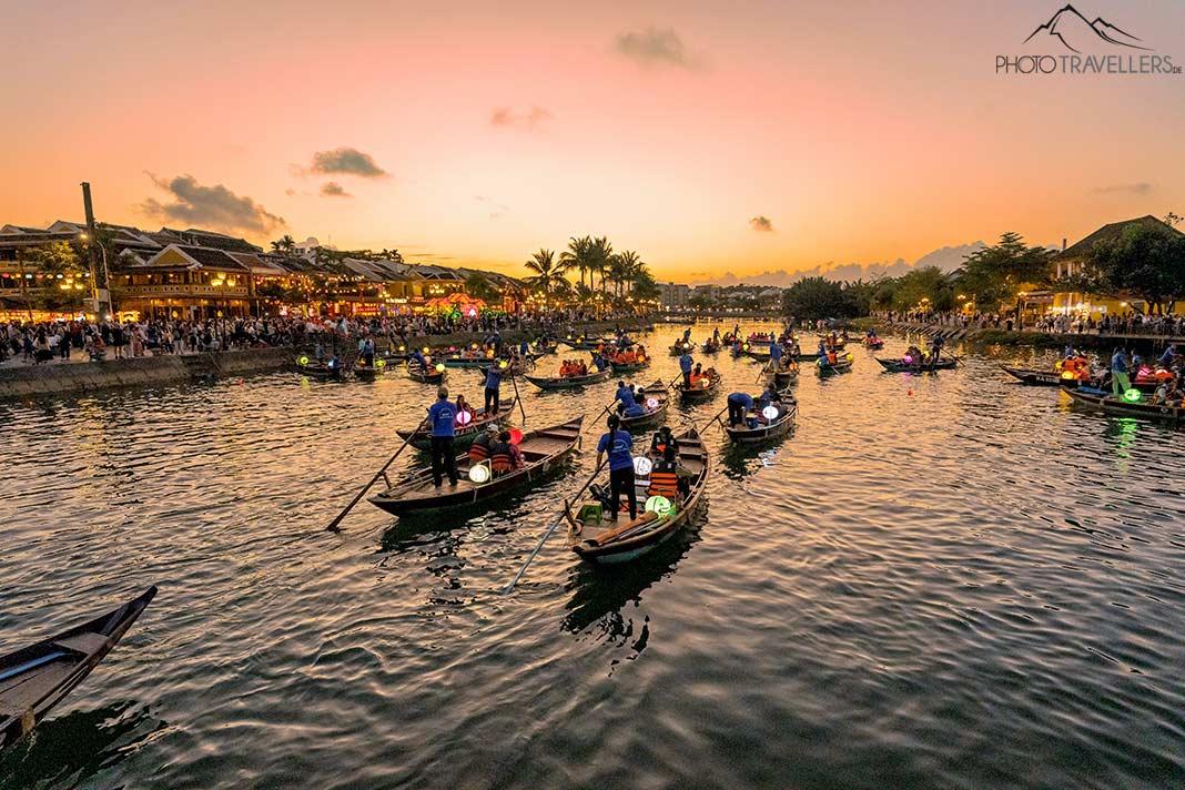 Bateaux à rames avec des touristes dans la lumière du soir sur la rivière à Hoi An