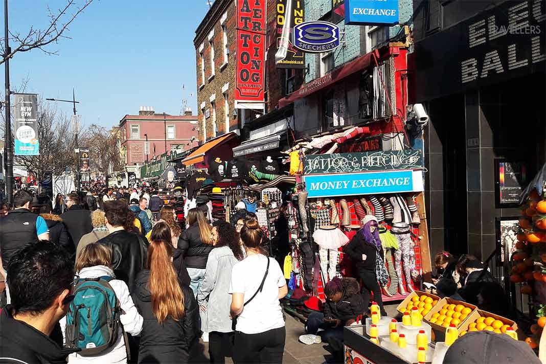 Beaucoup de gens se pressent devant les stands colorés autour des maisons du Camden Market