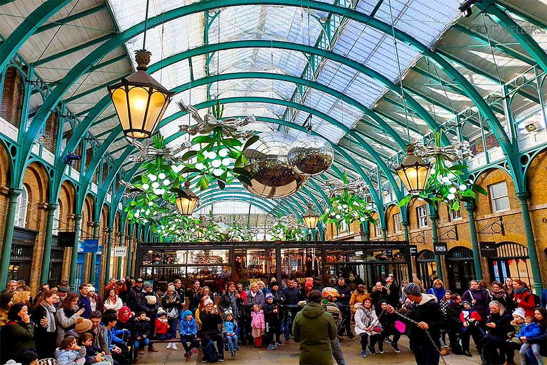 Sous le dôme en verre du Covent Garden Market, les clients admirent les artistes de rue