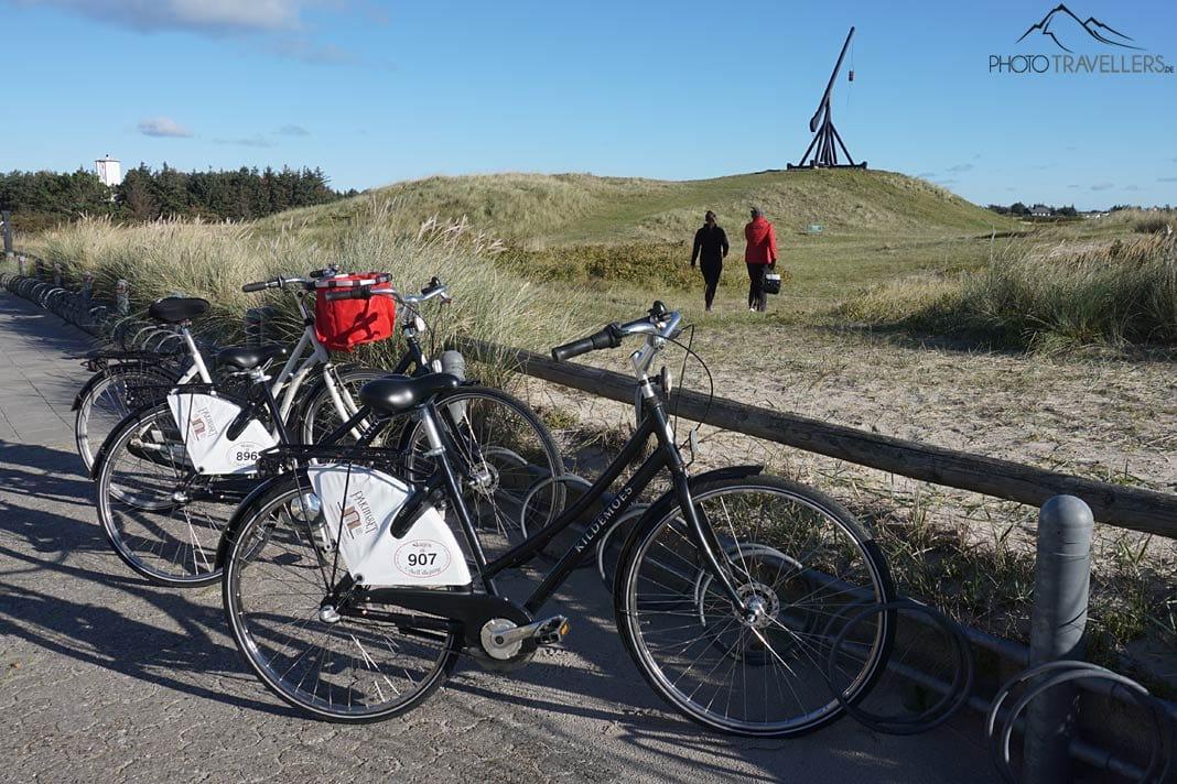 Des vélos au premier plan, derrière la blogueuse voyage Biggi Bauer avec une guide touristique en route vers le phare à bascule de Skagen