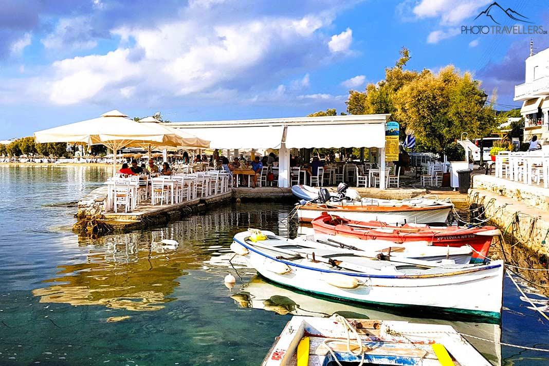 Pequeños barcos anclan frente a una taberna en el puerto de Aliki