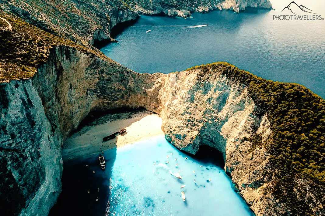La mer turquoise contraste fortement avec les rochers clairs et le sable de la plage de Navagio