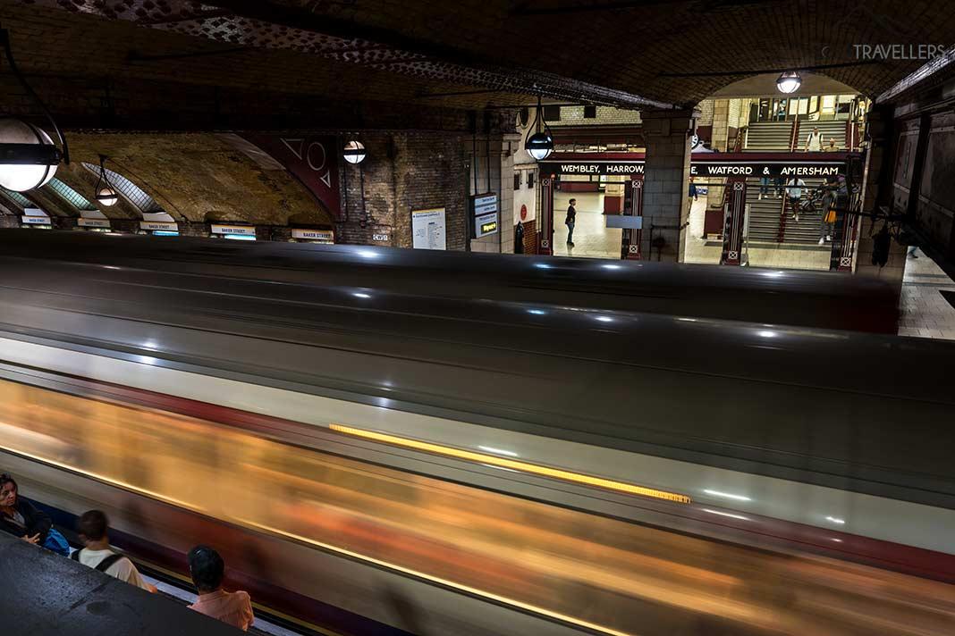 A longa exposição de um metrô entrando na estação Baker Street em Londres