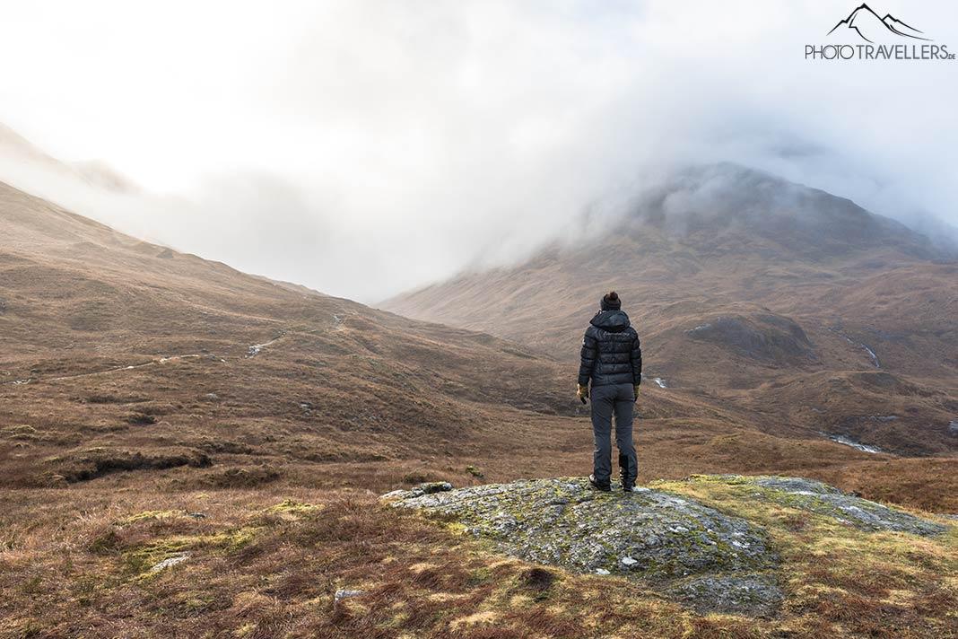 La blogueuse de voyage Biggi Bauer sur un sentier de randonnée dans la vallée de Glen Coe. Devant elle se dressent des montagnes hautes