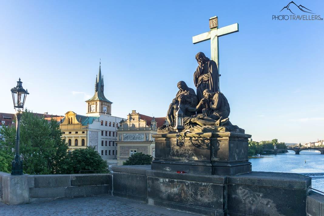 Estatuas com uma cruz na Ponte Carlos em Praga