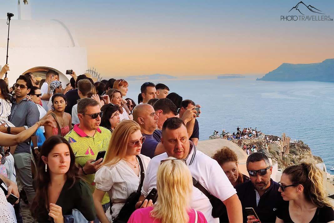 De nombreuses personnes se pressent dans les ruelles d'Oia pour admirer le coucher de soleil
