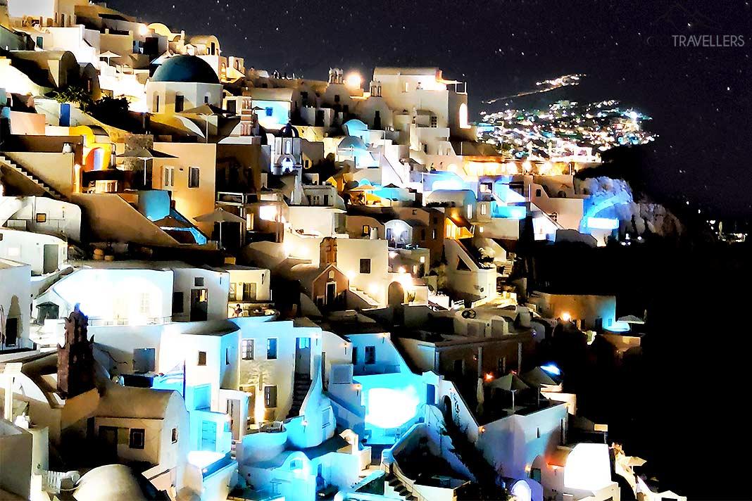 Les maisons blanches illuminées de Fira forment un fort contraste avec le ciel nocturne
