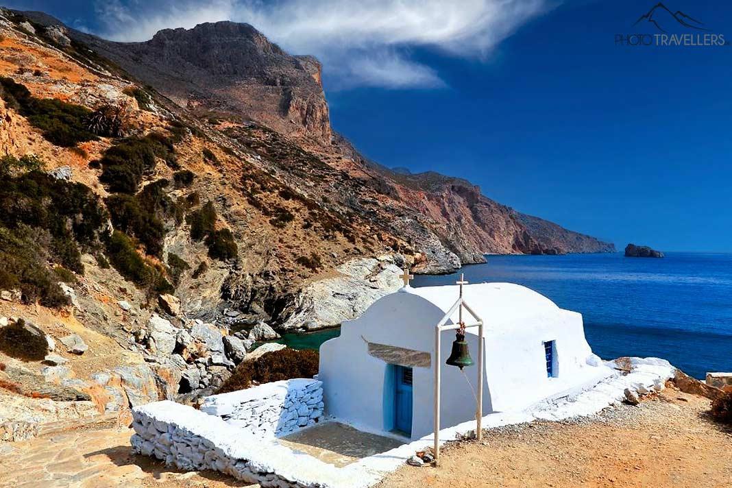 La chapelle blanche Agia Anna se dresse devant des falaises abruptes au bord de la mer