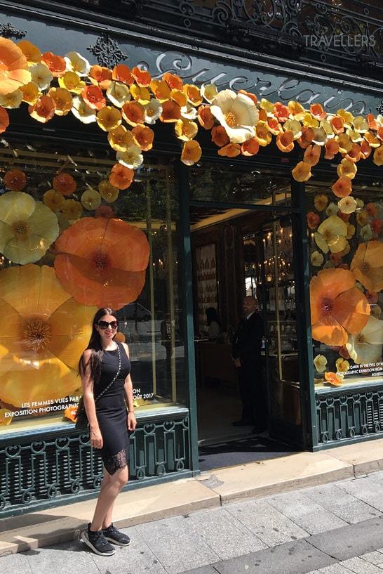Blogueira de viagens Biggi Bauer em frente à loja de luxo Guerlain na Champs-Élysées em Paris