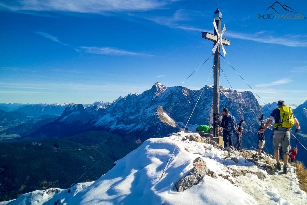 Caminhantes no cume do Daniel com a cruz do cume, ao fundo a Zugspitze