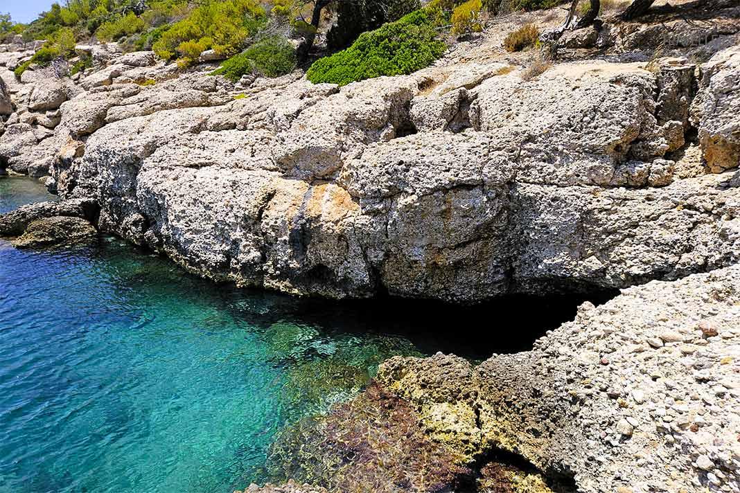 L'entrée de la grotte Bekiris se cache sous une falaise face à une mer turquoise