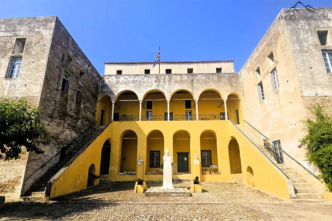 Des arches jaunes et blanches caractérisent la façade du musée Bouboulina avec un buste au premier plan