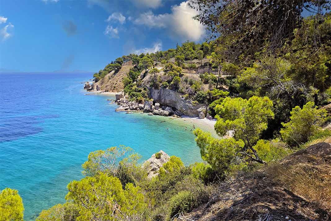 Une crique rocheuse boisée avec une mer turquoise