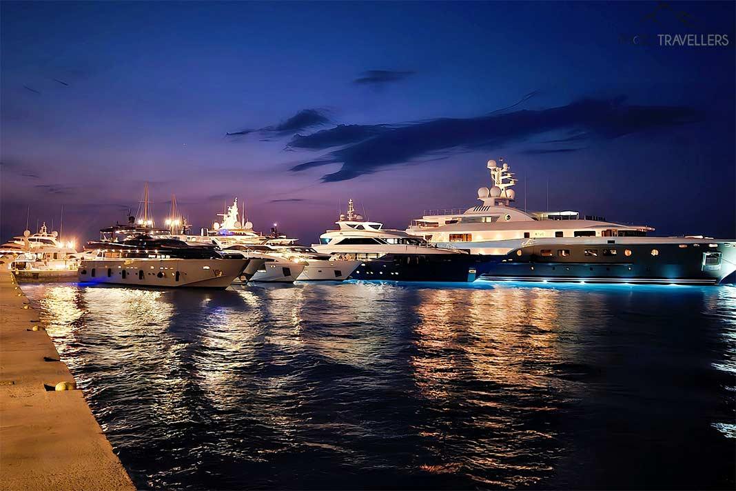 Des yachts de luxe illuminés ancrés côte à côte dans la lumière nocturne à Spetses
