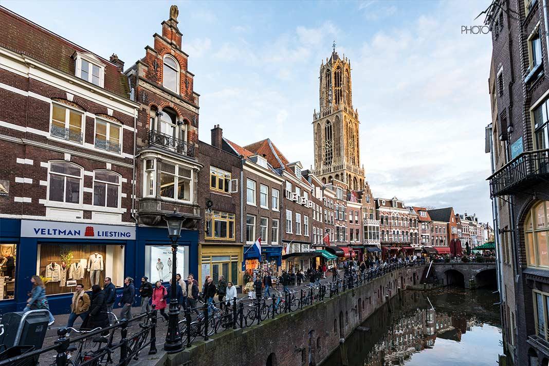 La tour Domtoren s'élève au-dessus des maisons historiques et d'un canal à Utrecht
