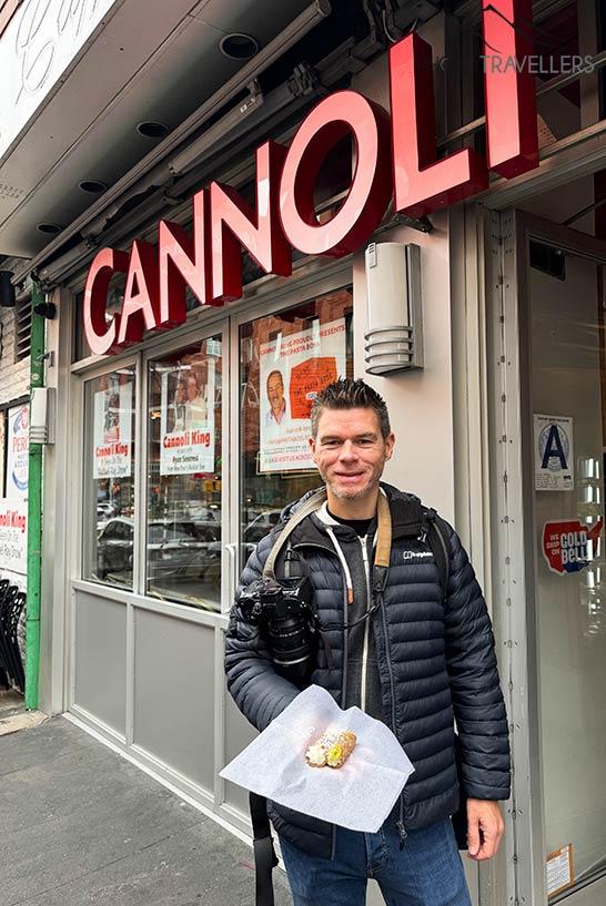 Le blogueur de voyage Florian Westermann devant le Caffé Palermo à New York avec deux cannoli