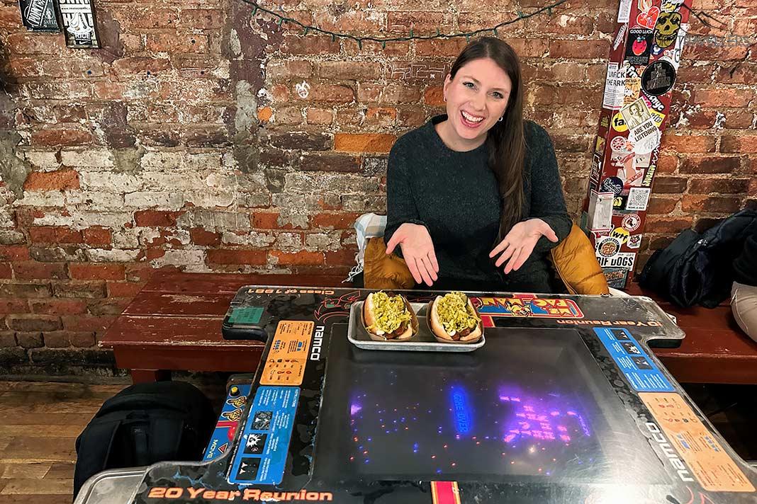 Le blogueur de voyage Biggi Bauer à table avec deux hot-dogs chez Crif Dogs à New York