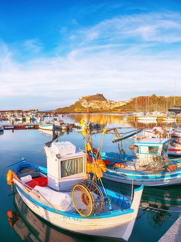 Barcos con la ciudad de Castelsardo al fondo