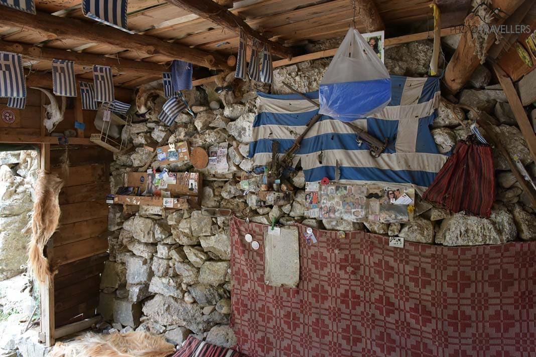 De petits souvenirs et des drapeaux grecs à l'intérieur de l'abri dans la gorge d'Imbros