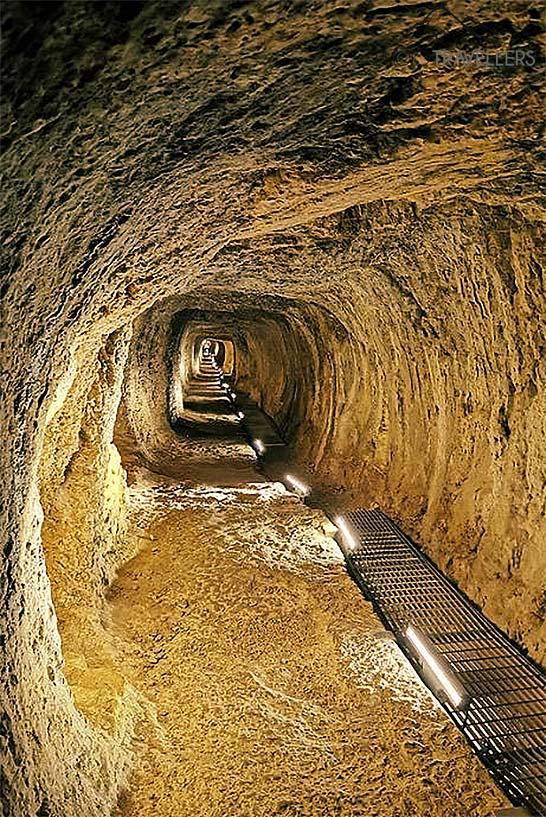 O estreito túnel iluminado de Eupalinos leva para o fundo da montanha