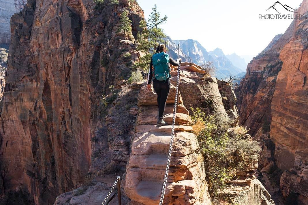 Blogueuse de voyage Biggi Bauer au point clé montant vers Angels Landing. À gauche et à droite, ça plonge verticalement