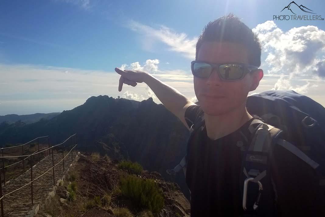 Voyageur Florian Westermann pointe du doigt la station radar au Pico do Arieiro