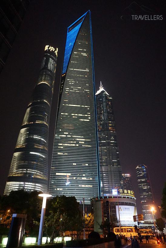 A vista de baixo para o Shanghai Tower e o Shanghai World Financial Center à noite
