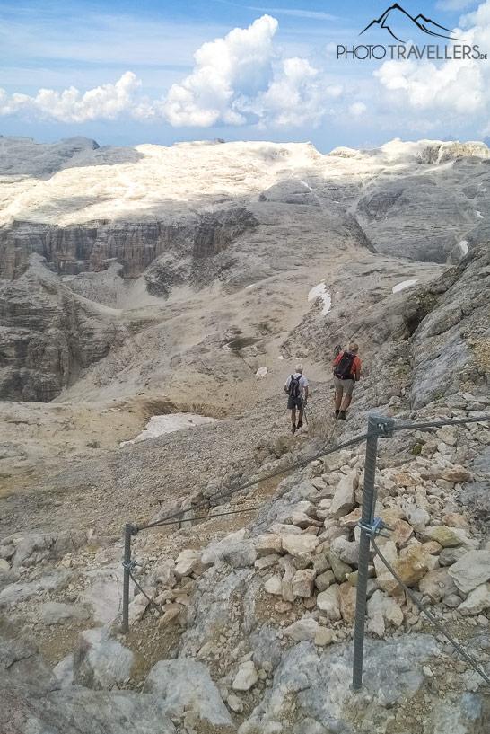 Dos senderistas bajan del Piz Boè por el camino asegurado con cuerda