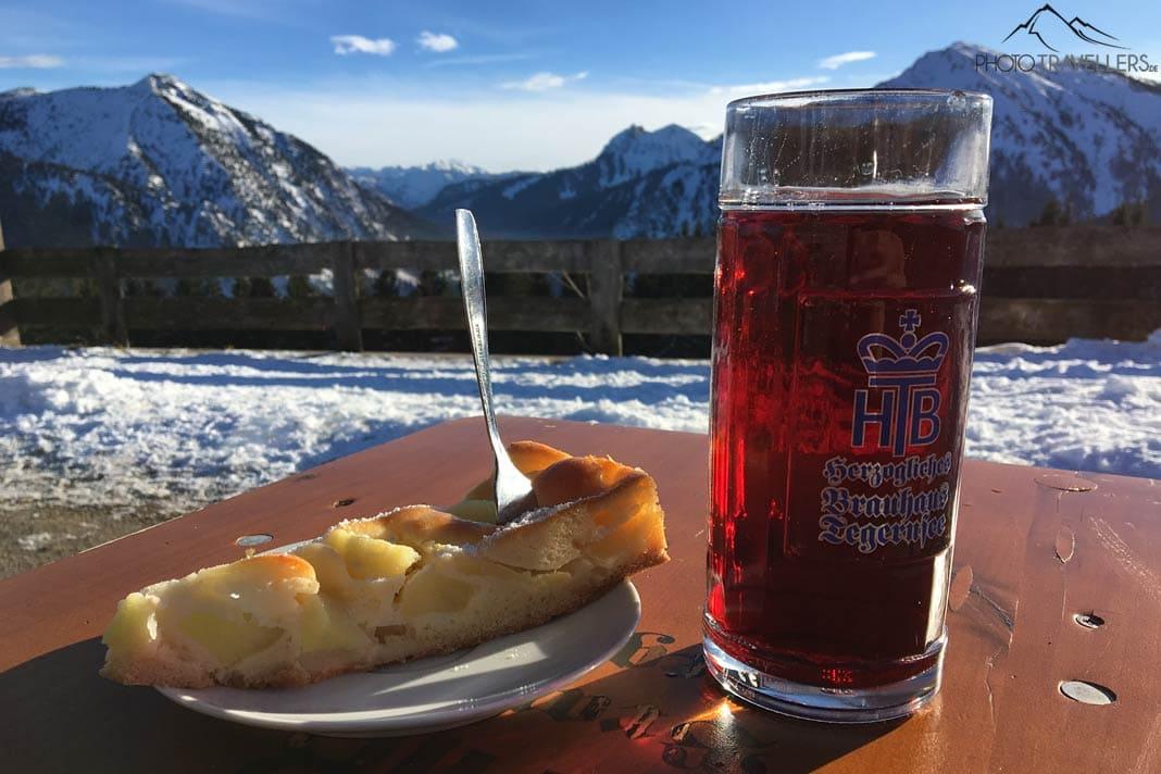 Un gâteau aux pommes avec une boisson au jus sur l'Aueralm avec vue sur les montagnes enneigées.