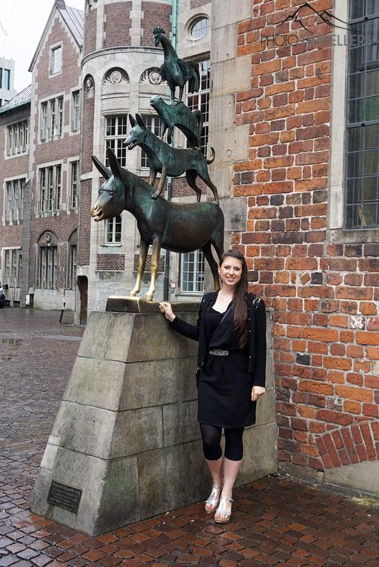 Journaliste de voyage Biggi Bauer devant la statue des Musiciens de Brême à Brême