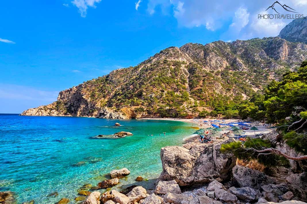 La plage d'Apella est entourée d'un paysage rocheux verdoyant