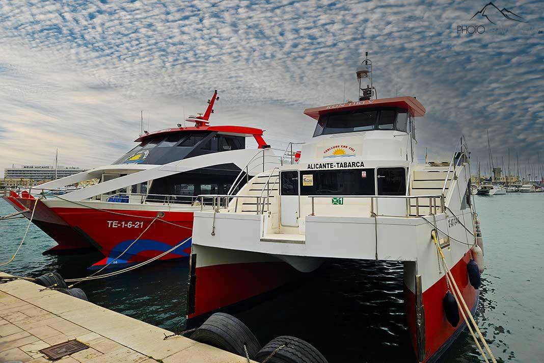 Deux catamarans peints en rouge et blanc sont ancrés dans le port