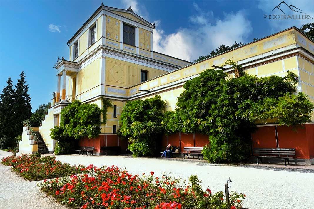 A Villa Pompejanum, de vários andares, está cercada por plantas e flores vermelhas