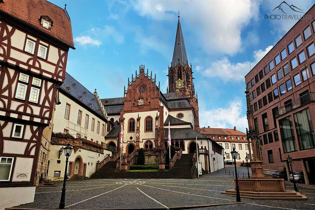A torre de pedra da Basílica de São Pedro e São Alexandre se destaca sobre a nave e os outros edifícios ao redor da praça pavimentada
