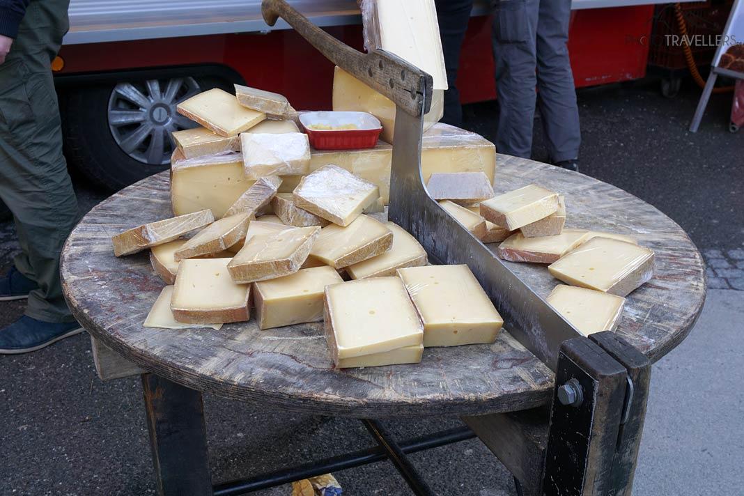 Una mesa con varios tipos de queso y un cuchillo en el mercado de Salzburgo