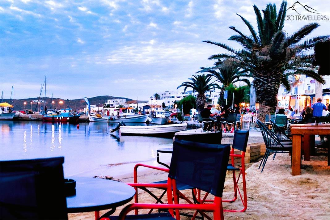 Des tables et des chaises colorées s'alignent le long de la promenade bordée de palmiers de Livadi