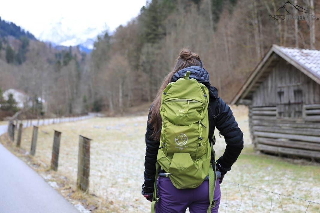 La bloguera de viajes Biggi Bauer con una mochila de senderismo verde en el camino que lleva a la Partnachklamm