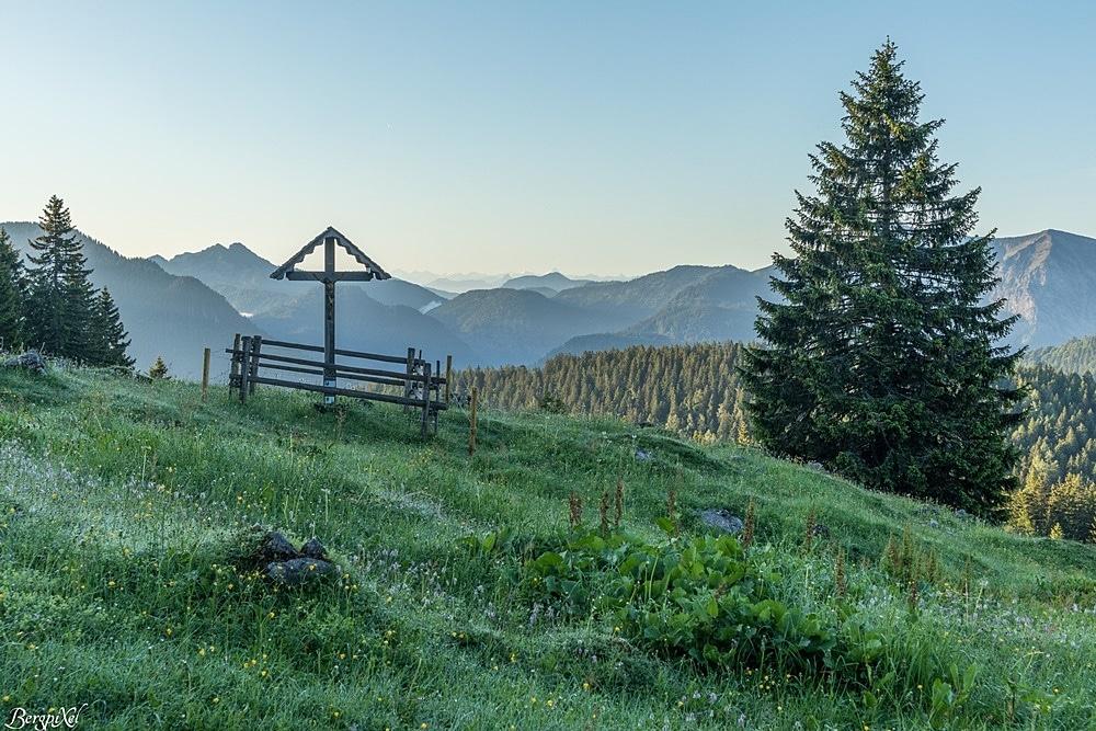 Un banc avec une croix dans les montagnes
