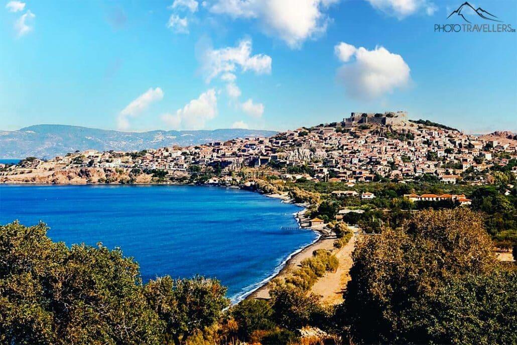 Les maisons en pierre de Molyvos s'alignent sous le château, avec des arbres devant dans la baie de Molyvos