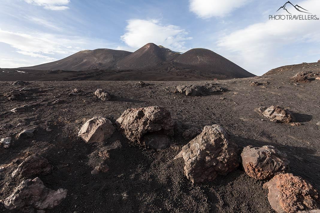 A vista dos cratérios do cume do Etna, com blocos de lava ao primeiro plano