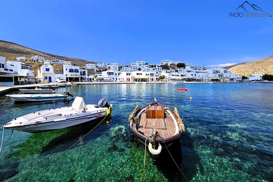 De petits bateaux sont ancrés dans les eaux turquoise devant les maisons blanches du village de pêcheurs de Panormos