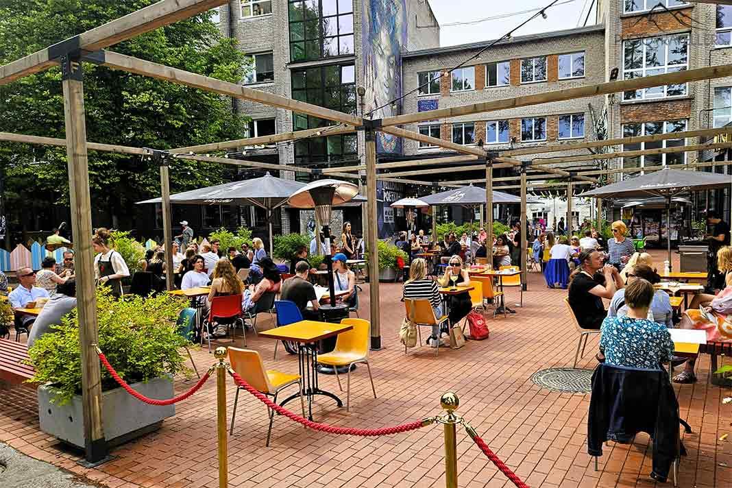 Des clients profitent d'un café en plein air dans le quartier branché de Telliskivi à Tallinn