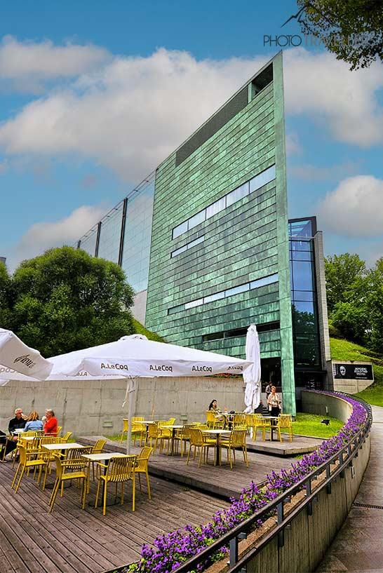 Chaises et tables d'un café devant le musée moderne Kumu à Tallinn