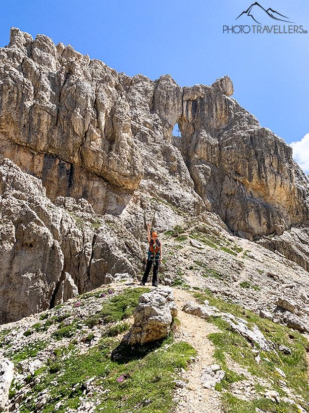 Blogueira de viagem Biggi Bauer diante do Torre Finestra, um torre de rocha com uma janela e uma cruz