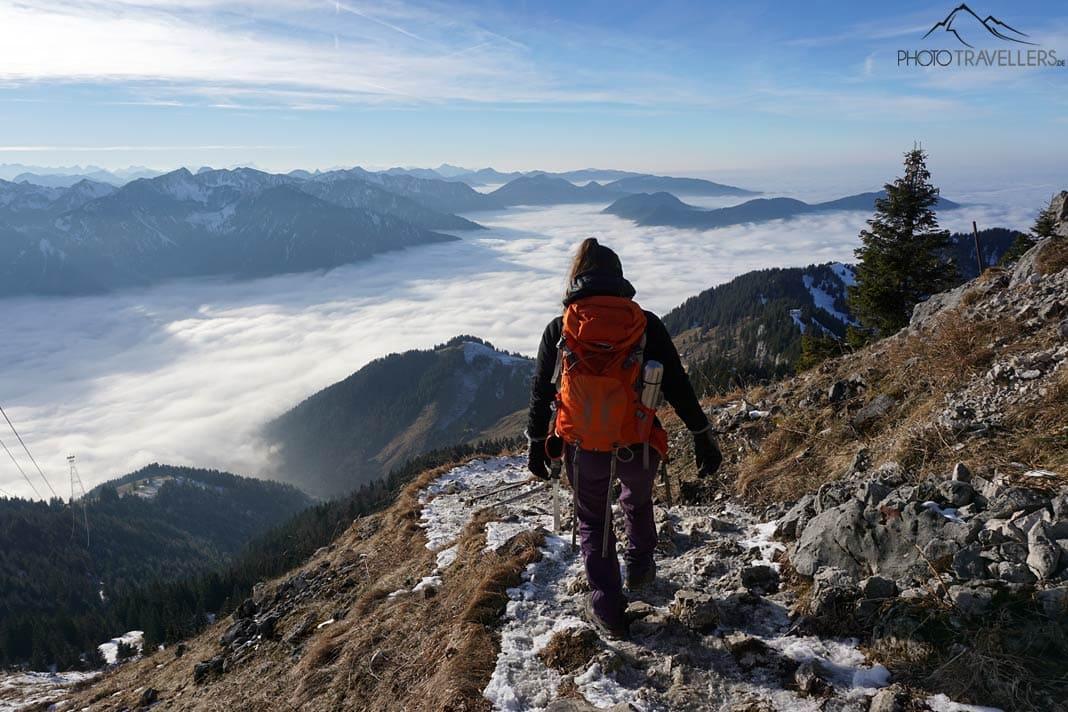 A influenciadora de viagens Biggi Bauer descendo pela Bocksteinscharte do Wendelstein, com o vale diante dela envolto em nuvens