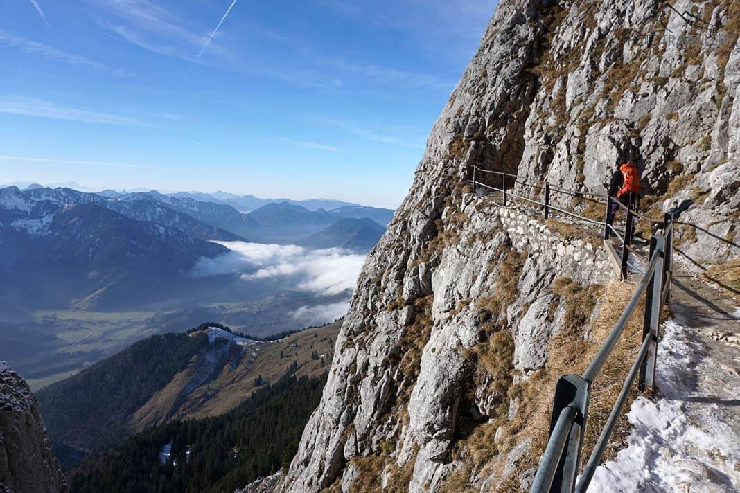 A influenciadora de viagens Biggi Bauer no caminho com proteção de corrimão para o cume do Wendelstein