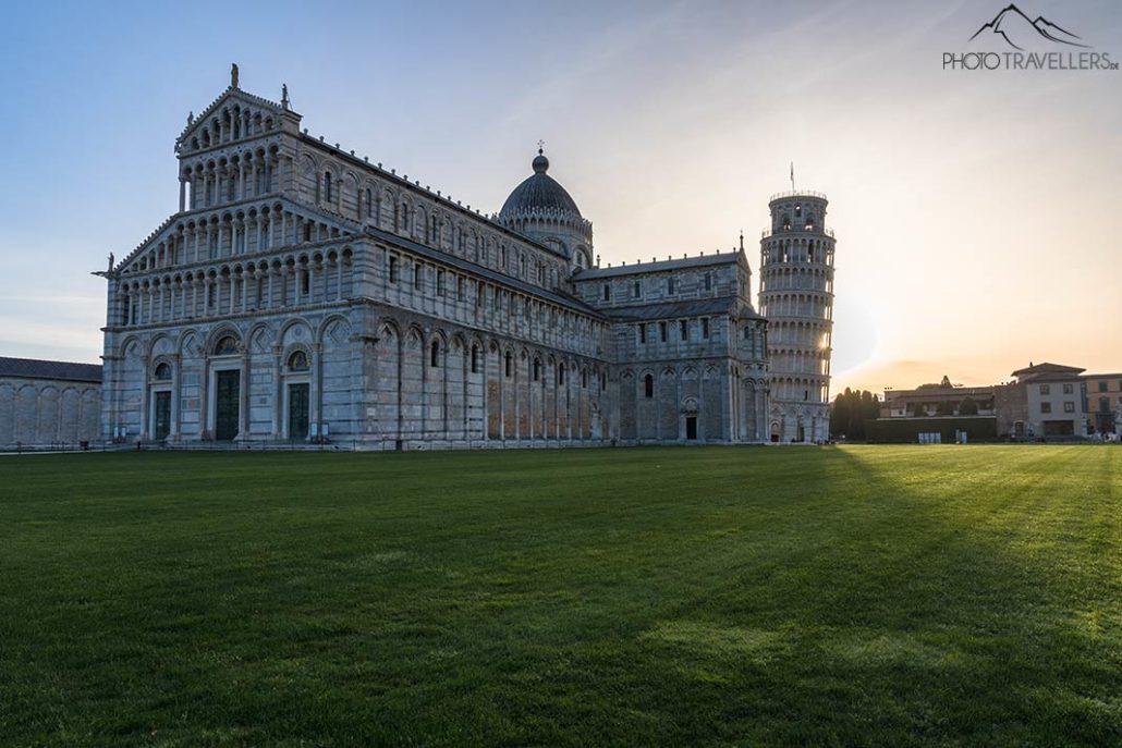 A Catedral de Santa Maria Assunta com a Torre Inclinada de Pisa ao amanhecer, ao fundo o sol nasce