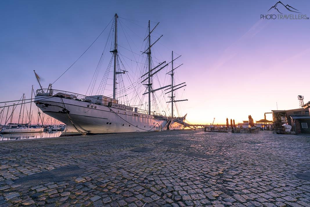 Le navire à voiles Gorch Fock à la lumière du lever du soleil dans le port de Stralsund